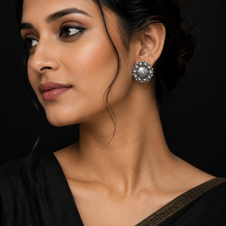 Close-up of a woman wearing a decorative 925 silver earring against a black background