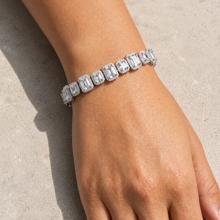 Diamond bracelet on a wrist against a neutral background