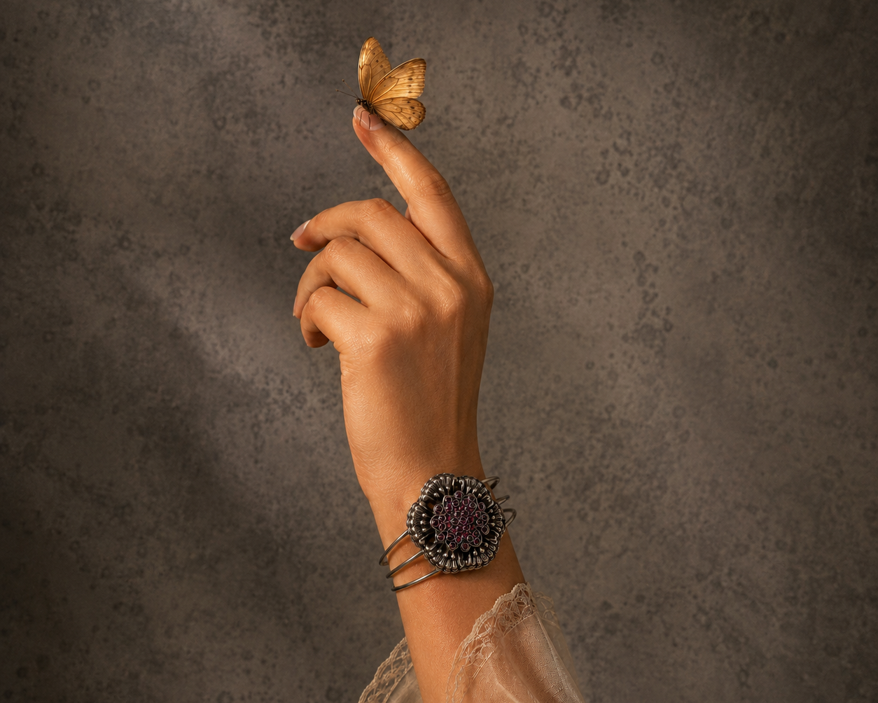 Hand with a silver bracelet and a butterfly on a textured brown background